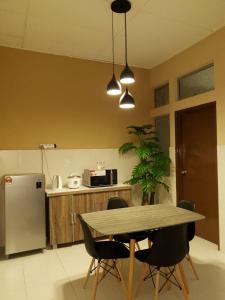 馬六甲的住宿－LindaNazri Homestay MITC Melaka，厨房配有桌椅和冰箱。
