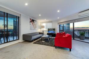 - un salon avec une chaise rouge et un canapé dans l'établissement The York by Swiss-Belhotel, à Sydney