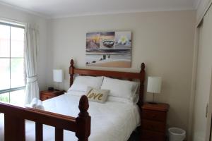 een slaapkamer met een bed met witte lakens en een foto bij Australian Home Away Ringwood Bardia in Ringwood
