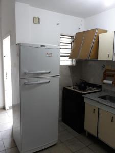 a kitchen with a white refrigerator and a stove at Departamento Catamarca in San Fernando del Valle de Catamarca