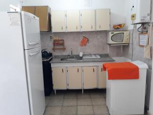 una pequeña cocina con nevera blanca y fregadero en Departamento Catamarca en San Fernando del Valle de Catamarca