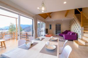 a living room with a table and chairs and a balcony at tocoro. Mt. Fuji Mutsuki in Fujikawaguchiko