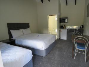 a hotel room with two beds and a kitchen at Grandeur Thermal Spa Resort in Taupo +32 photos
