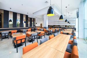 an empty restaurant with wooden tables and chairs at Holiday Inn Express Jakarta Matraman, an IHG Hotel in Jakarta