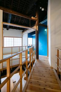 uma escada num quarto com paredes azuis e pisos em madeira em Machiya Hotel YANAGI em Quioto