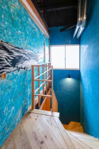 una escalera en una habitación con una pintura de ballenas en la pared en Machiya Hotel YANAGI en Kioto