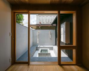 Machiya Hotel YANAGI في كيوتو: باب زجاجي لغرفة بها فناء