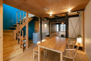 a dining room with a table and a staircase at Machiya Hotel YANAGI in Kyoto