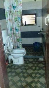 a bathroom with a toilet and a window at KOKDEERI NATURE HOME in Malappuram +2 photos