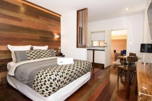 um quarto com uma cama com estampa de chita e uma mesa em Ettalong Beach Tourist Resort em Ettalong Beach