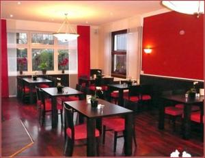 a restaurant with tables and chairs and red walls at Landgasthaus Hotel Wolters in Kerken