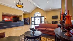 a living room with a couch and a table at SureStay Plus by Best Western San Antonio Fiesta Inn in San Antonio