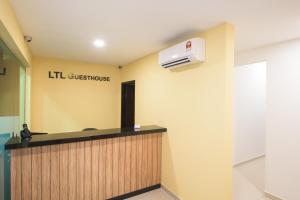 een wachtkamer met een gastenbord aan de muur bij LTL Guesthouse in Johor Bahru