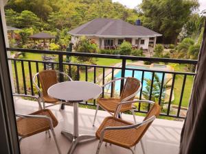 uma varanda com cadeiras e uma mesa e vista para uma casa em Garden Bungalows Resort em Siquijor