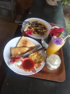 a table with two plates of breakfast food on it at Villas Ganjor in Gili Meno