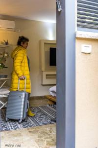 a woman in a yellow jacket with a suitcase at Zimmer you dreamed of in Arad