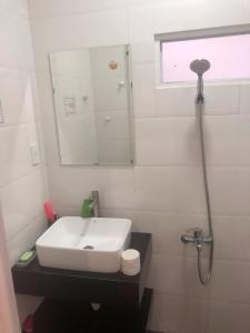 uma casa de banho branca com um lavatório e um espelho em Ruby Dalat Hostel em Da Lat