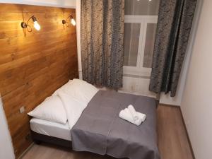 uma pequena cama com duas toalhas brancas em Apartament Skandia em Toruń