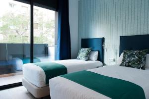 a hotel room with two beds and a window at MH Apartments Sant Pau in Barcelona