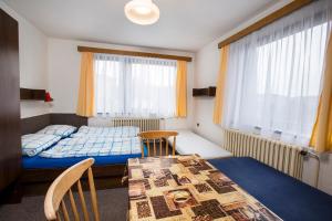 a bedroom with a bed and a table and chairs at Apartmán Braun in Rokytnice nad Jizerou