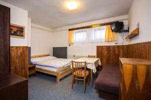 a small room with a bed and a table and a tableablish at Apartmán Braun in Rokytnice nad Jizerou