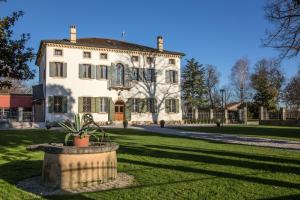 una gran casa blanca con una maceta en el patio en Villa Ormaneto, en Cerea