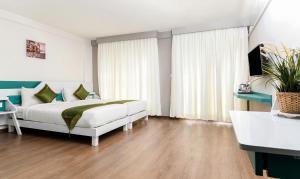 a bedroom with a bed and a large window at Treebo Trend Stay Tuned JP Nagar in Bangalore