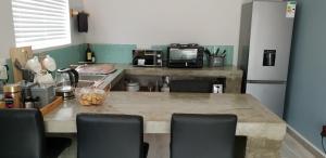 a kitchen with a table with chairs and a microwave at Emmaus Apartment in Bloemfontein