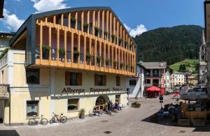 a building with people sitting outside of it at Active Hotel Rosat in Predazzo