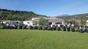 a group of people on motorcycles parked in a field at Hotel Baia Cea in Bari Sardo