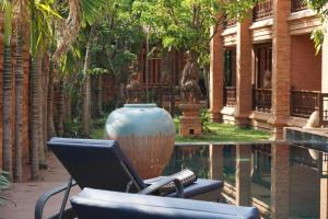a chair with a laptop on it next to a pool at Phor Liang Meun Terracotta Arts in Chiang Mai