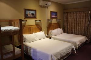 a hotel room with two beds and a window at Kalahari Lodge Kimberley in Kimberley