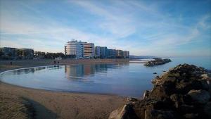 een strand met gebouwen op de achtergrond en de oceaan bij Grand Hotel Montesilvano in Montesilvano