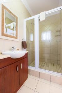a bathroom with a sink and a shower at Ocean Breeze Bloubergstrand in Bloubergstrand