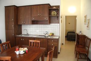 una cocina con armarios de madera y una mesa de madera con una comida. en C.A.V. Residenza Prisco, en Marina di Grosseto