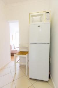 a white refrigerator with a microwave on top of it at Ocean Breeze Bloubergstrand in Bloubergstrand