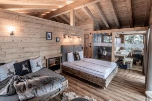 een slaapkamer in een blokhut met een bed en een open haard bij Benglerwald Berg Chaletdorf in Bach