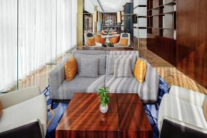 een woonkamer met een bank en een tafel bij Oriental Ginza Hotel Shenzhen in Shenzhen