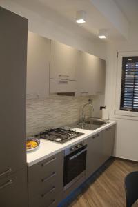 a kitchen with a sink and a stove top oven at Mamiani Suite in Castellammare del Golfo
