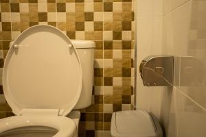 a bathroom with a white toilet and a toilet paper dispenser at Lazy Sandals in Ko Samed