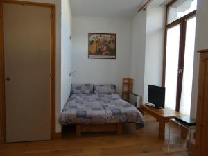 a bedroom with a bed and a desk with a television at Residence Le Carlton Cham in Chamonix