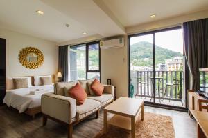 a bedroom with a bed and a couch and a balcony at The Deck Condominium Patong Beach in Patong Beach