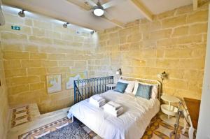 a bedroom with a bed in a stone wall at Eight Point Living 6B in Birgu