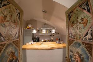 a kitchen with a counter with paintings on the walls at Leone Camere D'autore in Naples