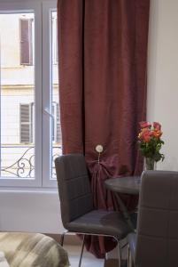 una habitación con una mesa y una ventana con un jarrón de rosas en Imperiale Top, en Roma