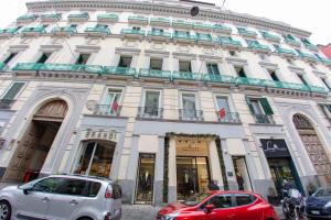 due auto parcheggiate di fronte a un edificio di Leone Camere D'autore - CHIAIA a Napoli