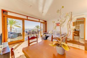 a living room with a table and a view of the ocean at Emma Beachfront Apartment in Port de Pollensa