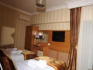 A bed or beds in a room at Alfa Hotel