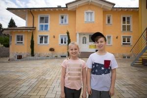 zwei kleine Kinder stehen vor einem Haus in der Unterkunft Rust-Fewo-Hotel in Rust