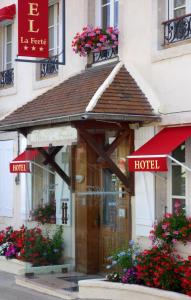 un edificio de hotel con una puerta de madera y flores en Hôtel De La Ferté, en Chagny